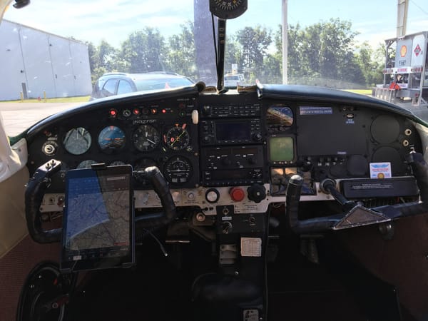 The full instrument panel from the centre, with the Garmin GNS 430W stack and an iPad running ForeFlight on the pilot yoke